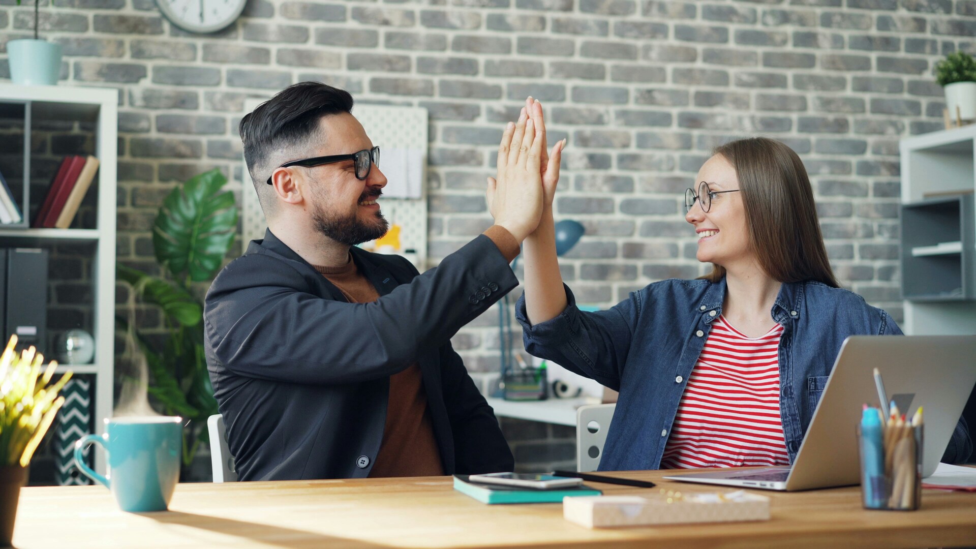 Un homme et une femme se claquant la main -L’égalité homme-femme en entreprise