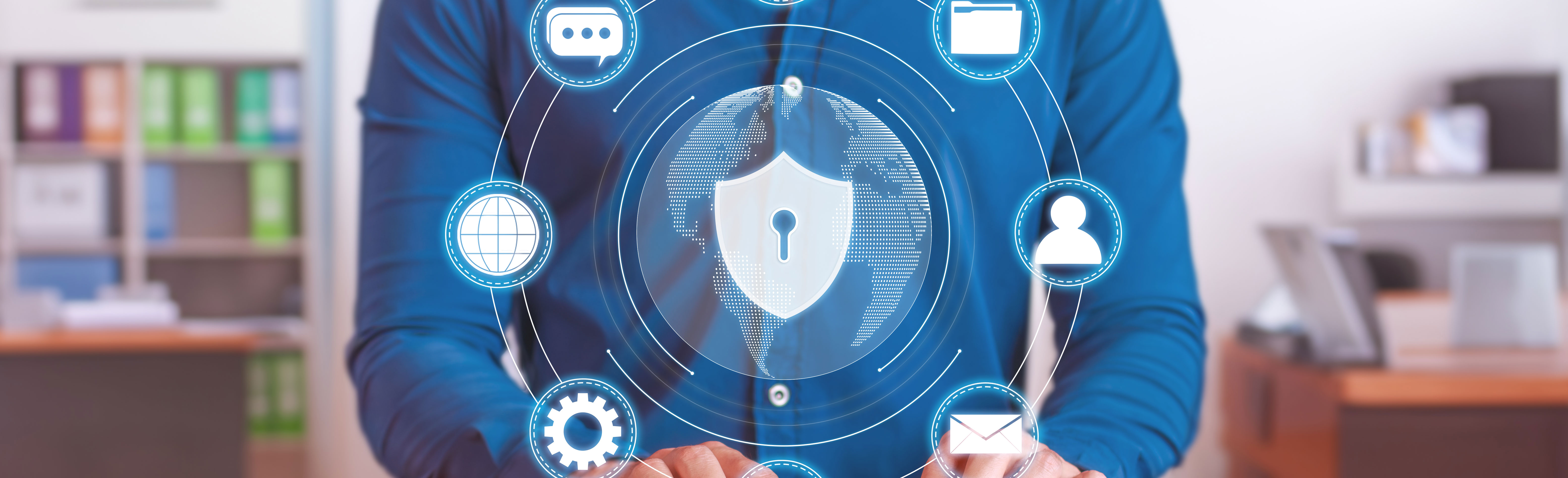 Homme en chemise tapant sur un clavier, entouré d’icônes numériques illustrant les enjeux de la cybersécurité en entreprise.
