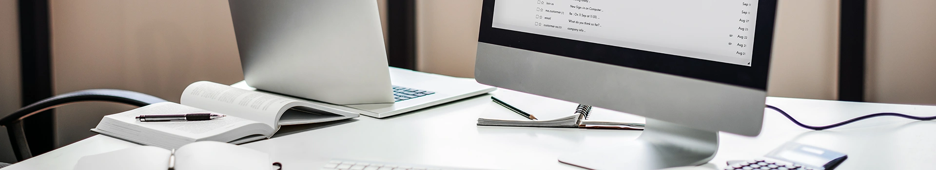 Photo d’un bureau professionnel avec ordinateur affichant une interface de messagerie, documents ouverts et outils de travail, illustrant un environnement de facturation électronique.