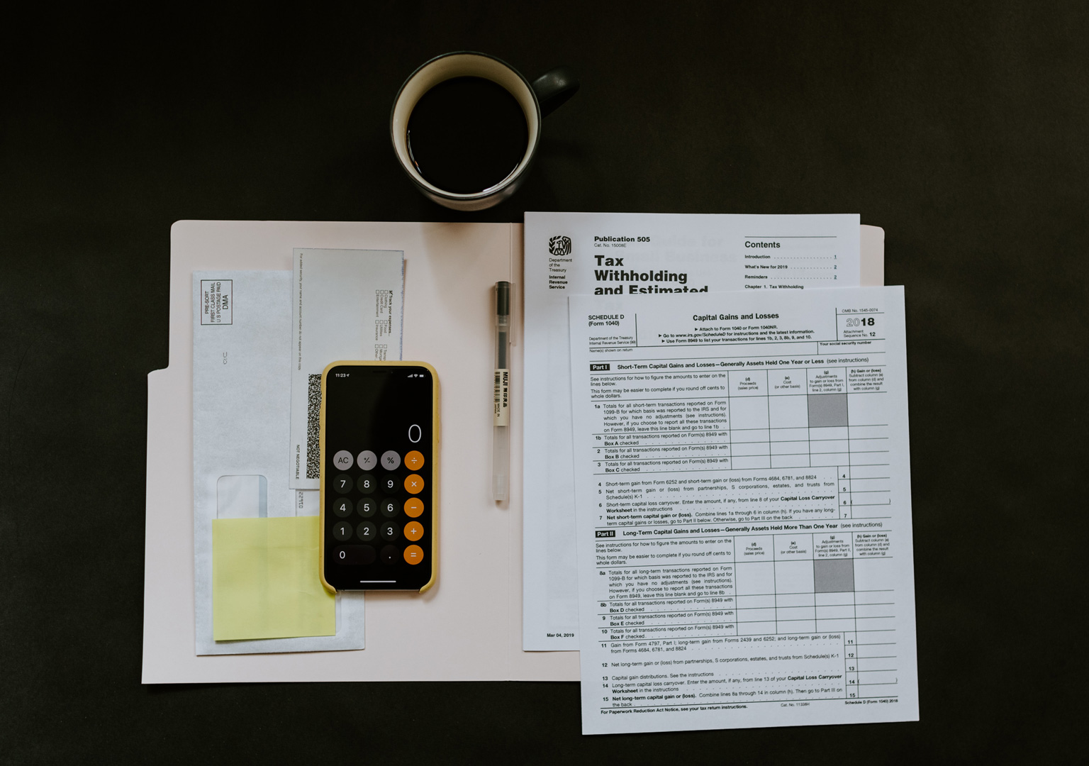 Documents fiscaux, calculatrice et tasse de café sur un bureau, illustrant le travail de comptabilité et l’estimation de rémunération.